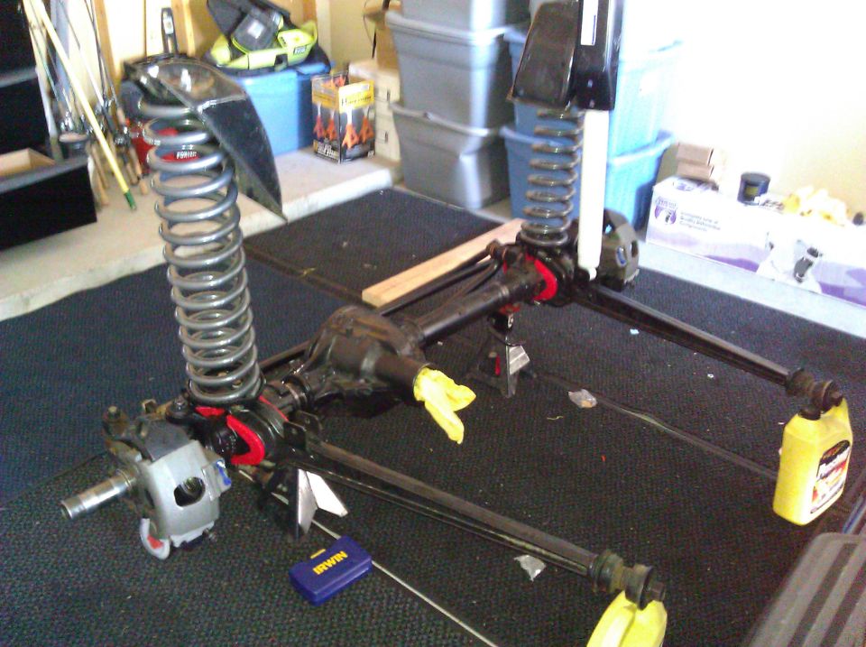 Front axle assembly with coil springs and shock mounts, on jack stands