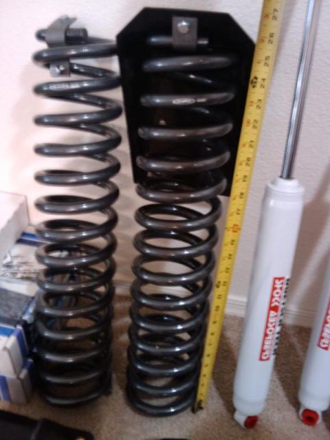 1995 Ford Bronco - Suspension components, including coil springs and shock absorbers, are laid out with a measuring tape for scale.