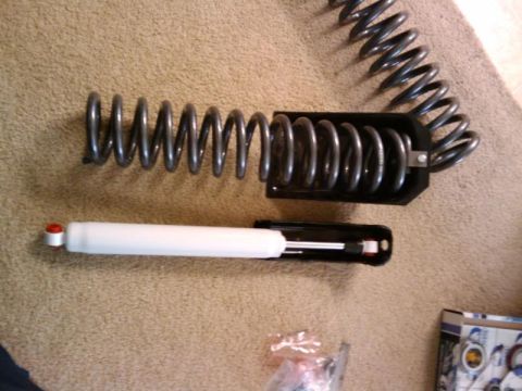 1995 Ford Bronco - Coil spring and shock absorber components laid out on a carpeted surface.