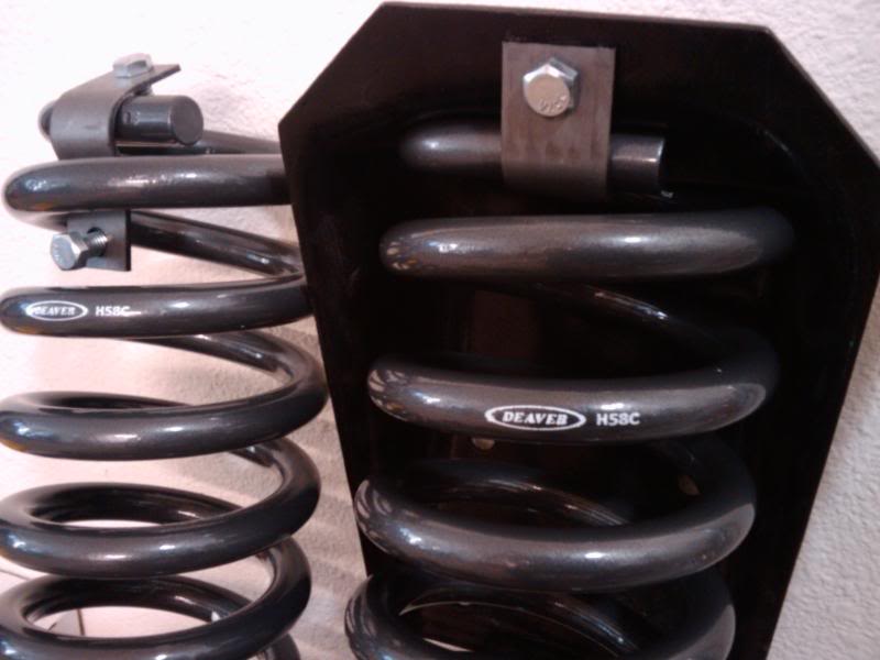 Two dark gray Deaver HSBC suspension springs, one attached to a black bracket