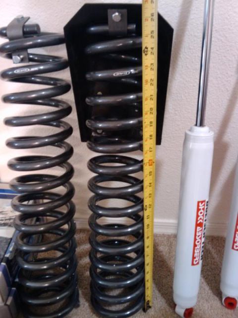 1995 Ford Bronco - Suspension springs and shock absorbers are shown with a measuring tape for scale. The text 'SUPERMOTORS' is visible at the bottom.