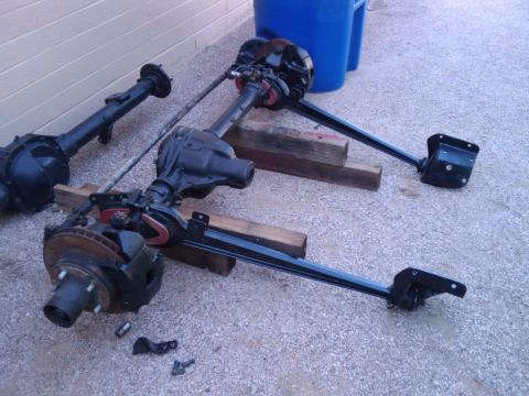 1995 Ford Bronco - Ford Bronco axles are shown disassembled and laid out on a concrete surface.