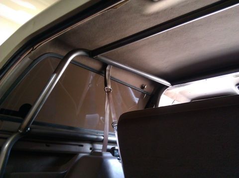 1995 Ford Bronco - The photo shows the interior of a vehicle, focusing on the installed roll cage and a seatbelt.