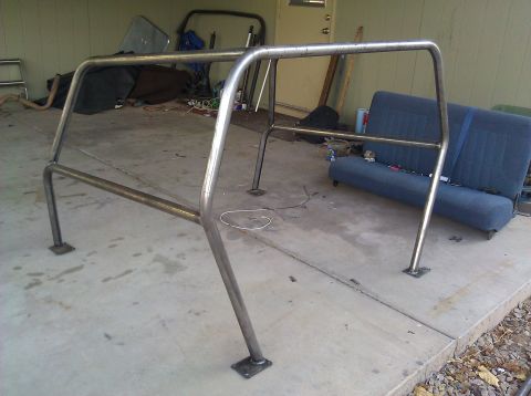 1995 Ford Bronco - A custom metal roll cage is shown, likely for off-road use, with a blue bench seat visible in the background.