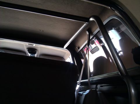 1995 Ford Bronco - The interior of a vehicle shows a metal roll cage structure and the headliner.