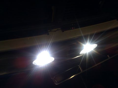 1995 Ford Bronco - Two bright interior lights illuminate the dark cabin, with visible lens texture.