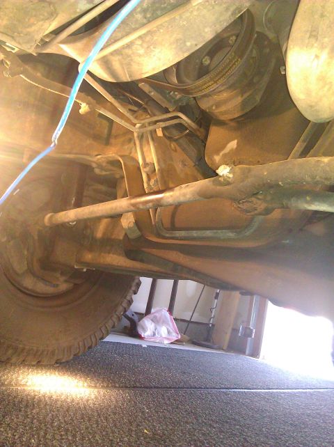 1995 Ford Bronco - Underside view of vehicle's suspension and drive belt system.