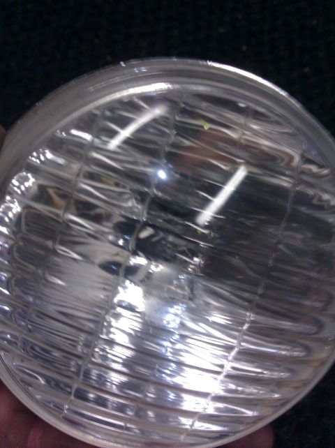 1995 Ford Bronco - A close-up view of a vehicle's headlight bulb, showing the intricate filament structure within the glass.