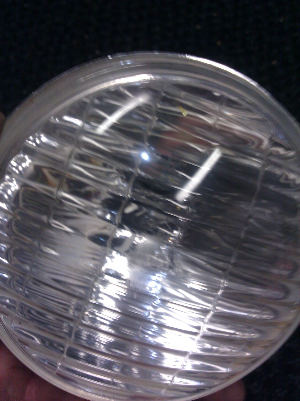 close-up of a clear glass headlight bulb with internal filament elements visible