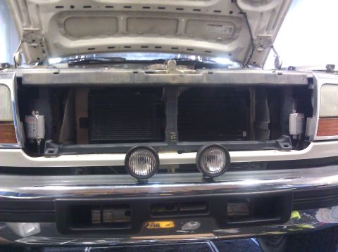 1995 Ford Bronco - Close-up view of the front grille and auxiliary lights of a vehicle with the hood up.