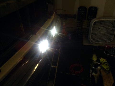 1995 Ford Bronco - Two bright auxiliary lights are mounted on the front of a vehicle, illuminating the dark.