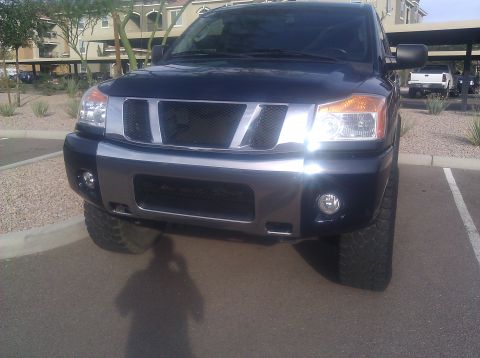 2008 Nissan Titan - Front view of a dark blue Nissan Titan pickup truck with a chrome grille and large tires, parked in a lot.