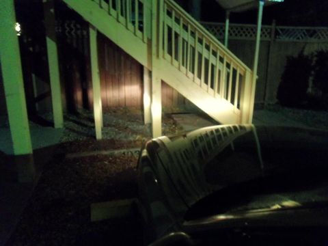 2000 Mercury Grand Marquis - Car hood and windshield seen at night with a wooden staircase in the background.