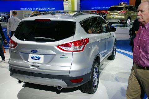 1993 Ford Taurus - Silver Ford SUV on display at an auto show, with a gold Ford SUV in the background.