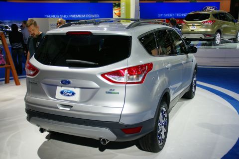 1993 Ford Taurus - A silver Ford Escape is displayed at an auto show, with another Ford SUV in the background.
