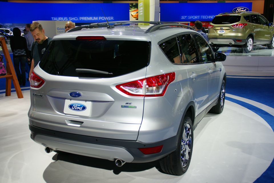 Silver Ford Escape SUV, rear view. Another gold Ford SUV is visible behind it