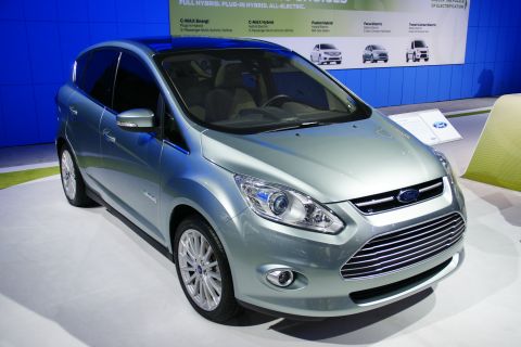 1993 Ford Taurus - A light blue Ford C-Max is displayed at an auto show, a prominent chrome grille and a panoramic sunroof.