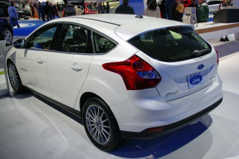 1993 Ford Taurus - A white Ford Focus hatchback is displayed at an auto show.