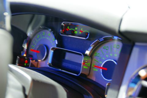 1993 Ford Taurus - The illuminated dashboard of a vehicle features green-lit gauges and a digital display.