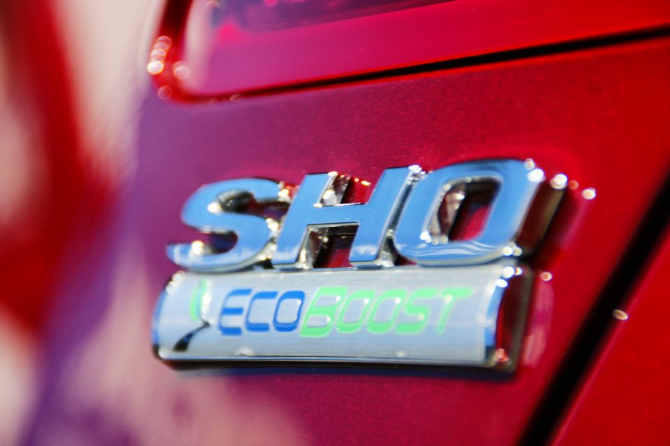Red car rear emblem reads SHO EcoBoost