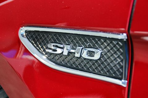 1993 Ford Taurus - Chrome SHO badge on the fender of a red Ford Taurus.