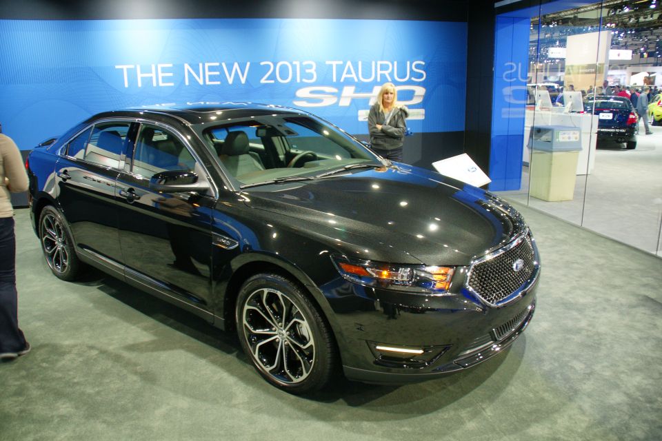 Black 2013 Ford Taurus sedan on display at an auto show