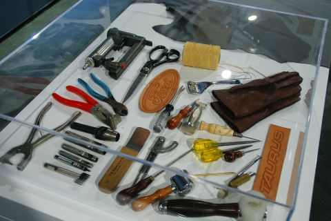 1993 Ford Taurus - A collection of tools and leather samples, including Ford and Taurus branding, are displayed in a case.