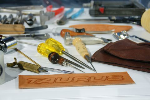 1993 Ford Taurus - Leather stamping tools are laid out next to a piece of leather embossed with the word TAURUS.