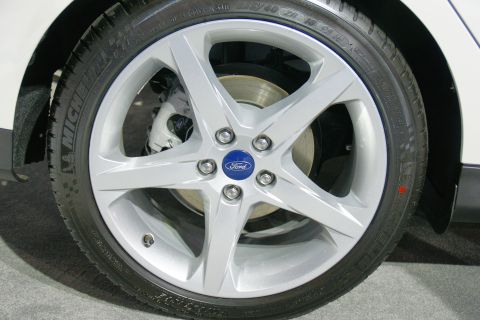 1993 Ford Taurus - Close-up of a Ford wheel and tire assembly, showing the brake caliper behind the spokes.