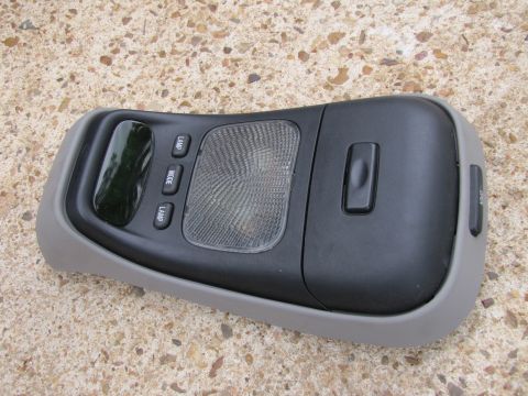 1995 Ford Bronco - This overhead console features lamp and mode buttons, along with a dark tinted window.