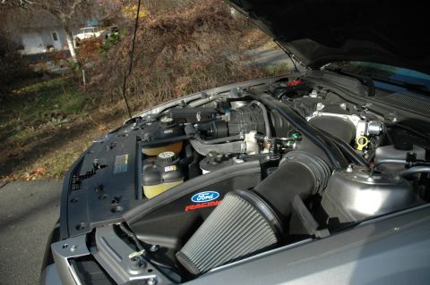 2008 Ford Mustang - Engine bay of a silver Ford Mustang a Ford Racing performance air intake system.