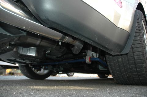 2008 Ford Mustang - Close-up of a car's rear suspension components and exhaust system.