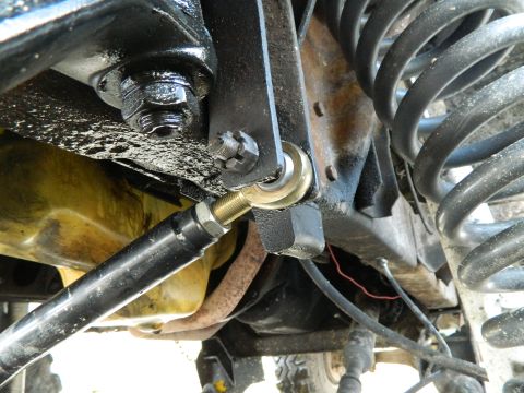 1979 Ford Bronco - Undercarriage view of a vehicle's suspension system, showing linkage and spring.