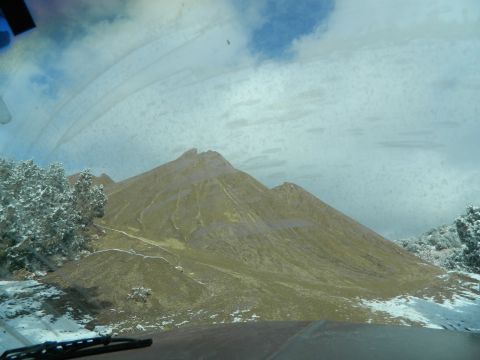 1979 Ford Bronco - A scenic mountain view is observed through a windshield covered in dirt and water spots, with a Supermotors watermark at the bottom.
