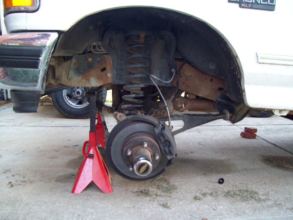 1996 Ford Bronco XLT rear suspension on jack stands, showing lifted components and brake assembly