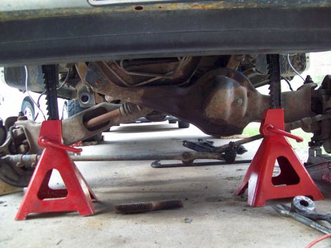 1996 Ford Bronco - Vehicle's rear axle and suspension components are visible while supported by jack stands.