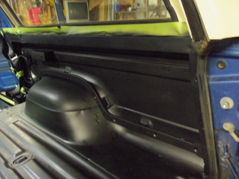 1985 Ford Bronco - The interior of a blue vehicle is shown, with focus on the rear wheel well and floor, suggesting restoration work.