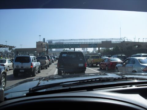 1986 Ford Bronco - View from inside a vehicle stuck in a long traffic line at a border crossing.