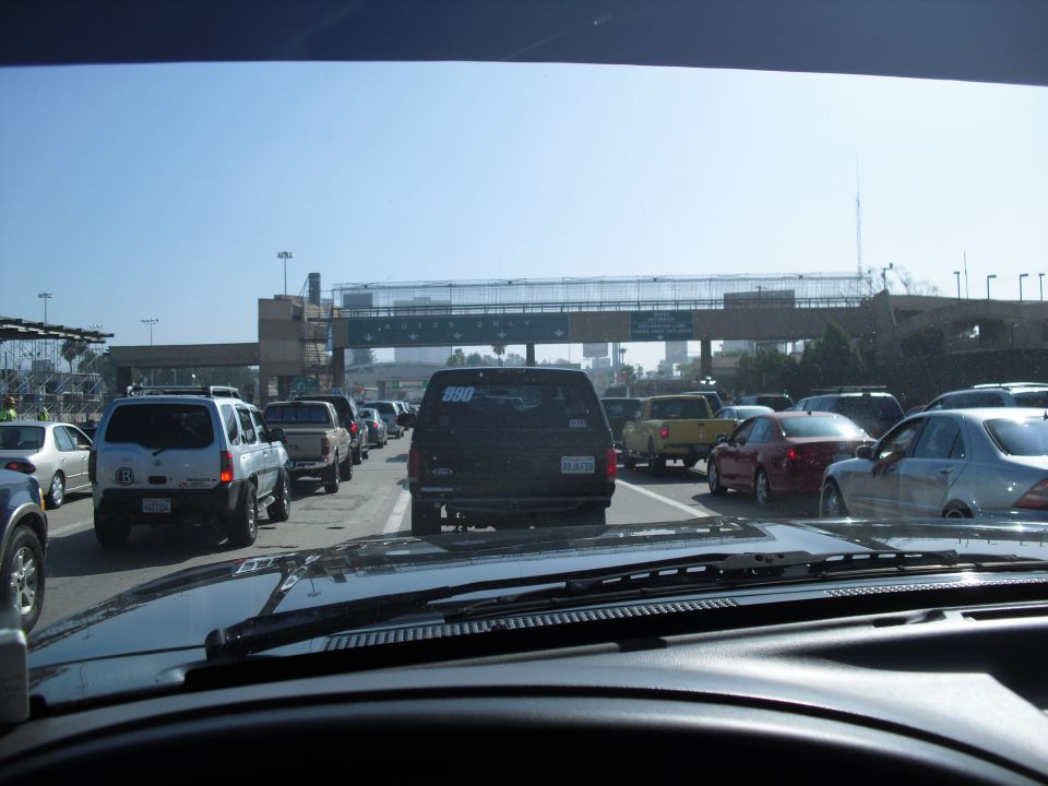Traffic jam at a border crossing with multiple cars and trucks lined up