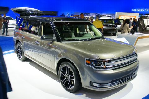 1993 Ford Taurus - A gray Ford Flex is displayed at an auto show with its rear hatch open.