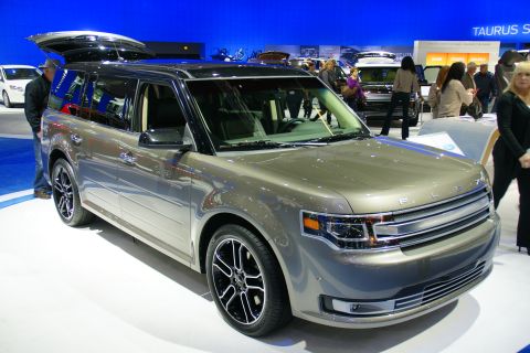 1993 Ford Taurus - A tan SUV with a black roof and tinted windows is displayed at an auto show.