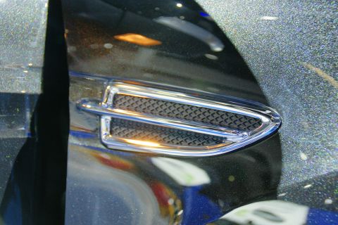 1993 Ford Taurus - Detail of chrome trim and grille on a vehicle's fender.