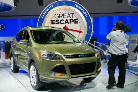 1993 Ford Taurus - A green Ford SUV is presented at an auto show with a "Great Escape" sign in the background.