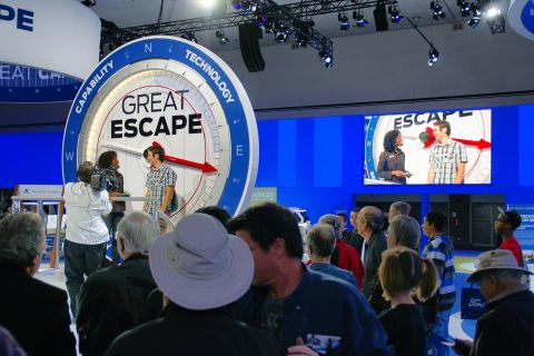 1993 Ford Taurus - People gather around a large 'GREAT ESCAPE' display at an auto show event.