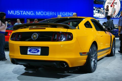 1993 Ford Taurus - A yellow Ford Mustang is displayed at an auto show with "MUSTANG. MODERN LEGEND" visible in the background.