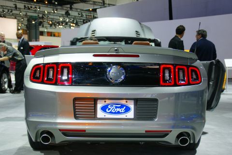 1993 Ford Taurus - Rear view of a silver Ford Mustang convertible, likely a 2010 model, displayed at an auto show.