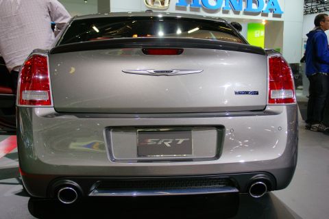 1993 Ford Taurus - The rear of a silver Chrysler 300 SRT is visible, the SRT badge and dual exhaust.