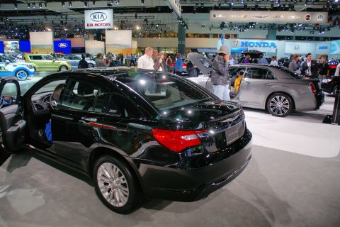 1993 Ford Taurus - Black Chrysler 200 and silver Chrysler 300 on display at an auto show.