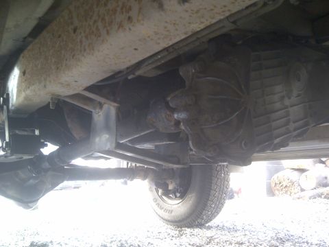 1979 Ford E250 - This photo shows the underside of a vehicle, focusing on the drivetrain components like the transmission and driveshaft.