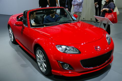 1993 Ford Taurus - Red Mazda MX-5 Miata convertible on display at an auto show.